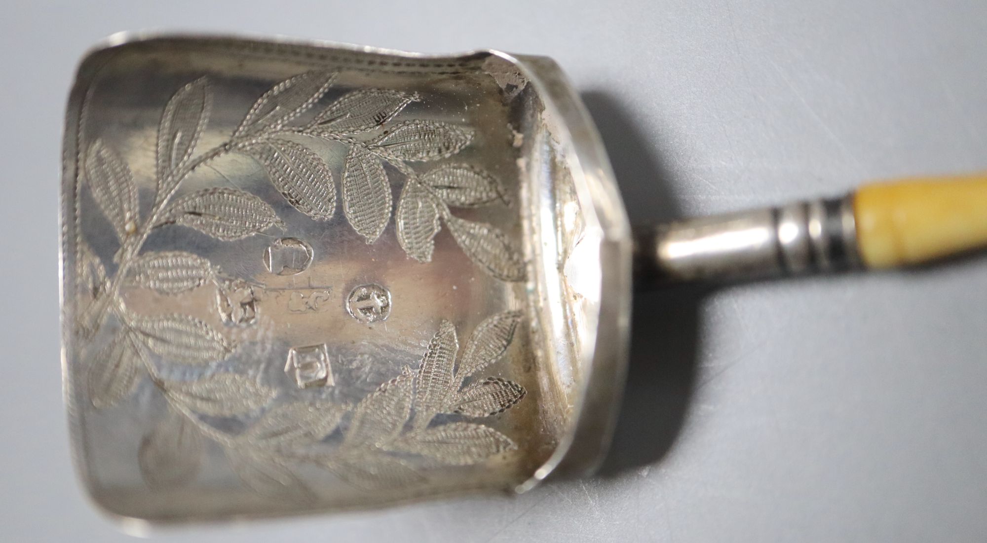 A 1950s Georg Jensen sterling pickle fork and a George III ivory handled silver caddy spoon.